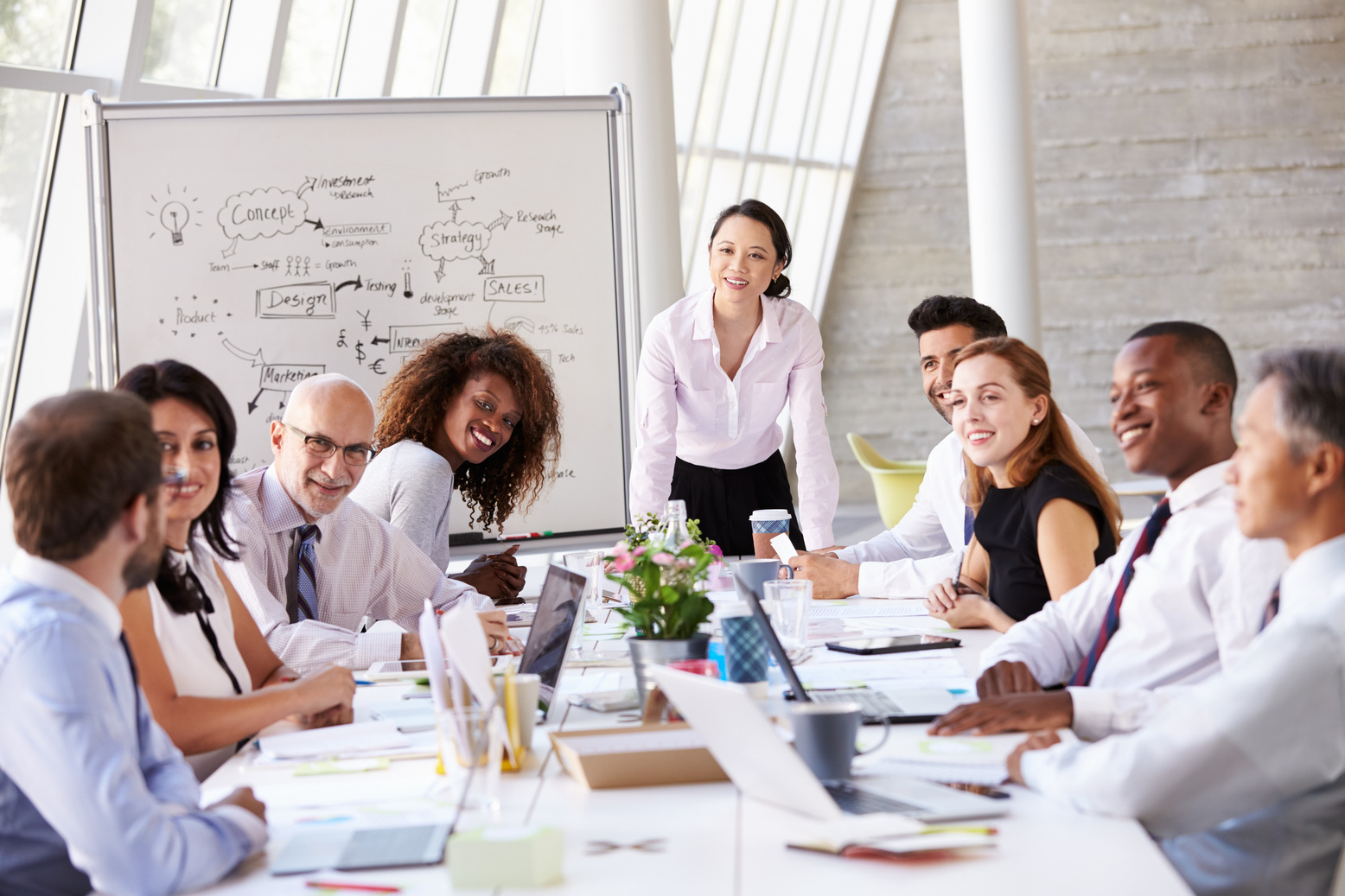 Asian Businesswoman Leading Meeting at Boardroom Table